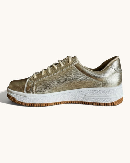 Zapatillas EQUILIBRIO ZAPATOS by EIM doradas con textura, suela de plataforma blanca y base de goma color caramelo.